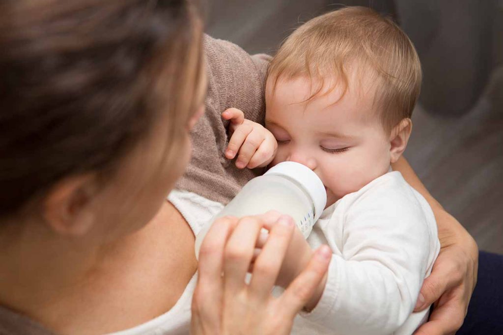 Maternity nurse feeding child